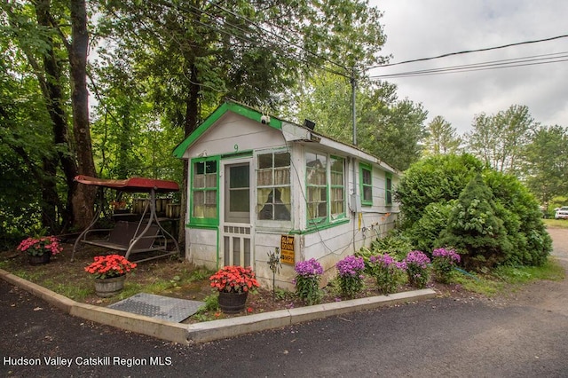 view of outbuilding featuring a sunroom