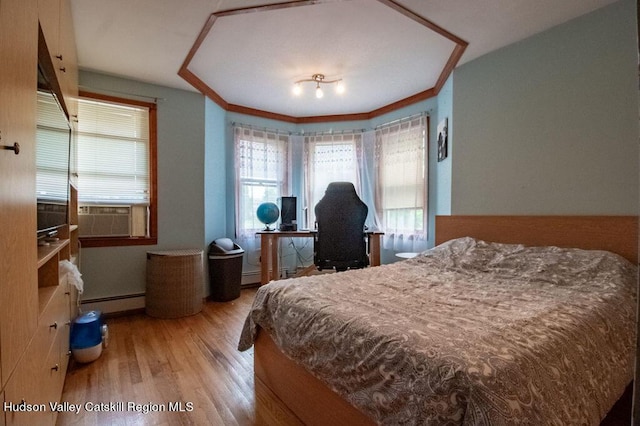 bedroom with hardwood / wood-style flooring, a baseboard radiator, and cooling unit