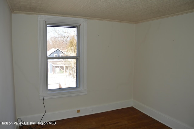 unfurnished room with baseboards, an ornate ceiling, ornamental molding, and dark wood-style flooring