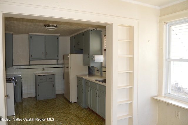 kitchen featuring plenty of natural light, gray cabinetry, crown molding, and freestanding refrigerator