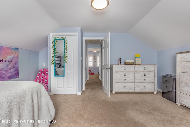 bedroom featuring light colored carpet, vaulted ceiling, and baseboards