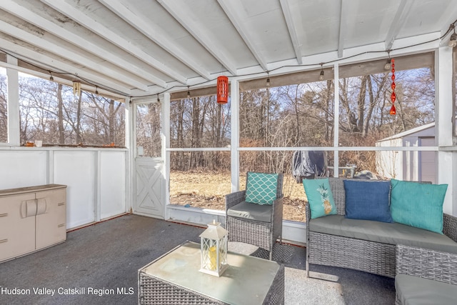 unfurnished sunroom featuring beam ceiling and a wealth of natural light