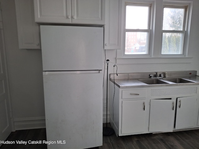 kitchen featuring white cabinetry, white fridge, sink, and dark wood-type flooring