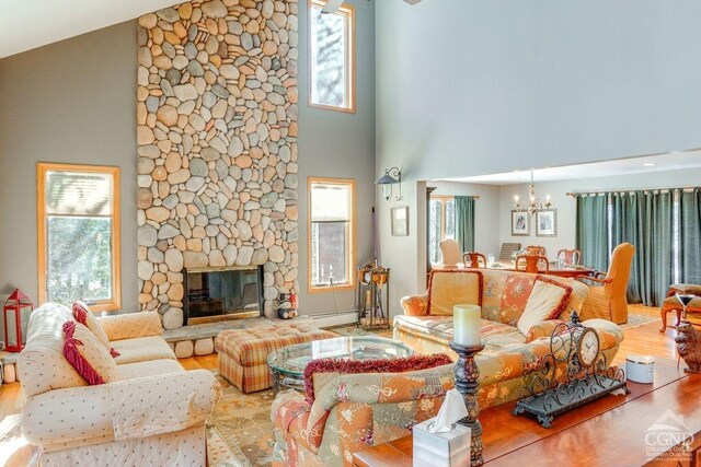 220 Botti Dr, Hunter, NY 12442 - living room with wood finished floors, a chandelier, high vaulted ceiling, and healthy amount of natural light