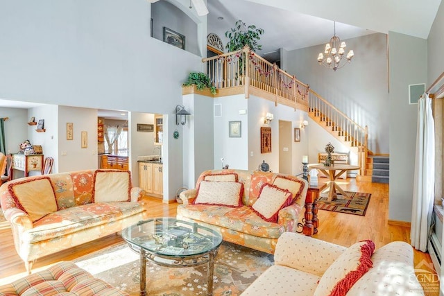 220 Botti Dr, Hunter, NY 12442 - living room featuring stairway, a towering ceiling, light wood-type flooring, and a chandelier