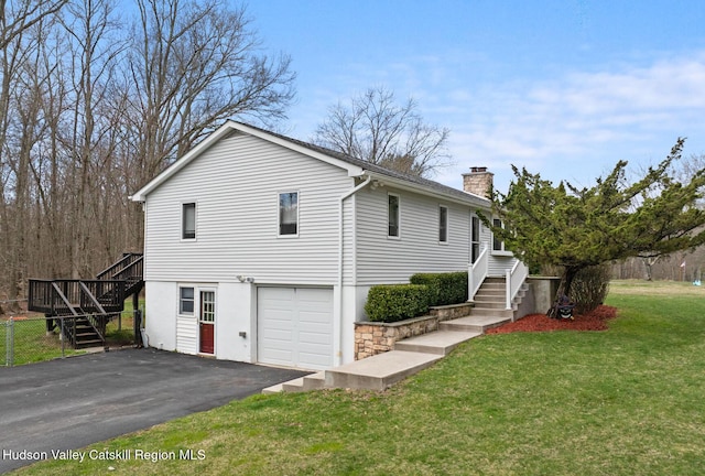 view of front of property with a chimney, stairway, a front lawn, aphalt driveway, and a garage