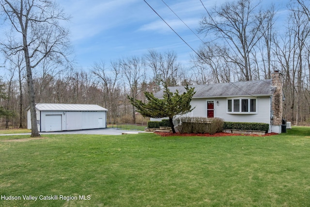 view of yard with driveway, an outdoor structure, and a garage