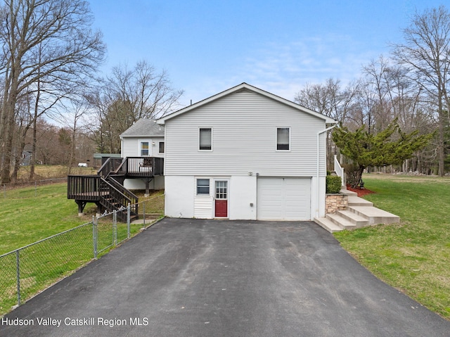 view of side of home with an attached garage, a yard, aphalt driveway, and stairs