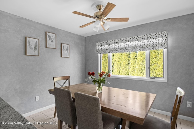 dining area with light tile patterned floors, ceiling fan, and baseboards