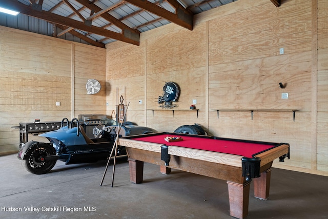 recreation room featuring finished concrete flooring, wood walls, high vaulted ceiling, and billiards