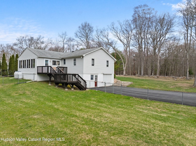 rear view of property with an attached garage, a lawn, stairs, driveway, and roof with shingles
