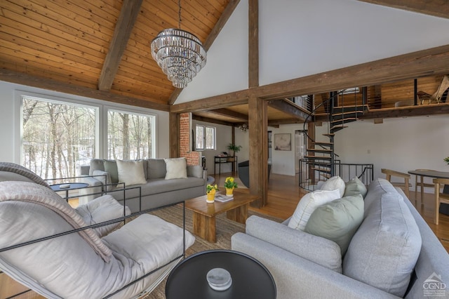 living room with beamed ceiling, wood finished floors, stairway, a chandelier, and high vaulted ceiling