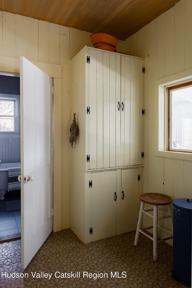 interior space featuring wood walls, tile patterned flooring, and wood ceiling