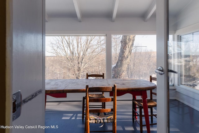 dining space with plenty of natural light and beamed ceiling