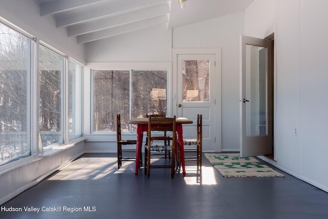 sunroom / solarium featuring vaulted ceiling with beams