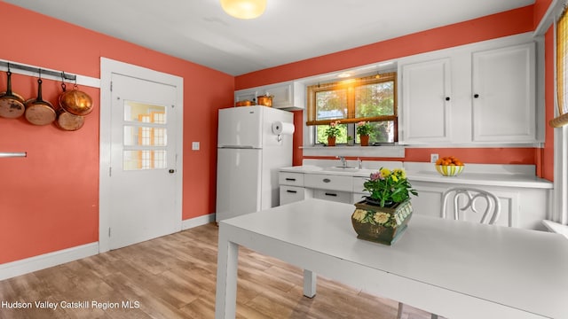 7 Paul Ave, Hudson, NY 12534 - kitchen featuring freestanding refrigerator, white cabinetry, light countertops, and light wood-type flooring