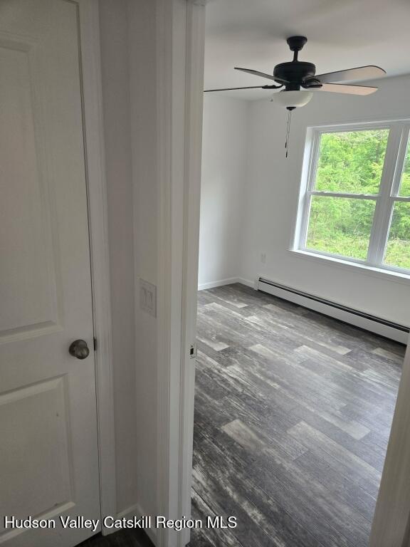 4791 US Highway 209, Accord, NY 12404 - unfurnished room featuring a baseboard radiator, ceiling fan, and wood finished floors