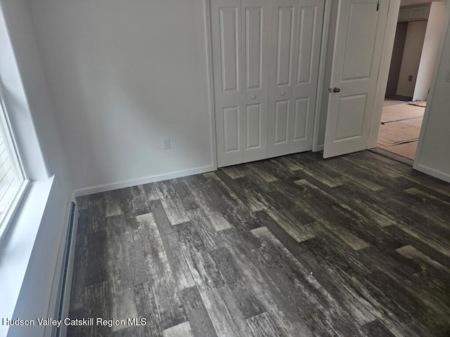 4791 US Highway 209, Accord, NY 12404 - unfurnished bedroom with dark wood-style flooring, a closet, and a baseboard heating unit