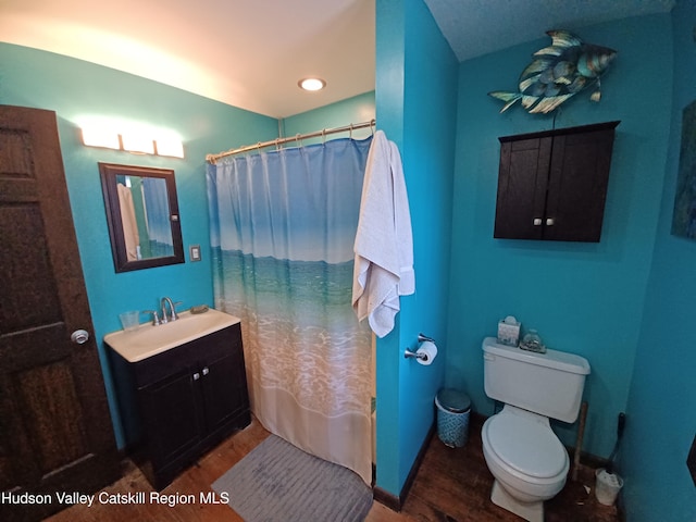 full bathroom featuring hardwood / wood-style flooring, vanity, toilet, and shower / bath combo