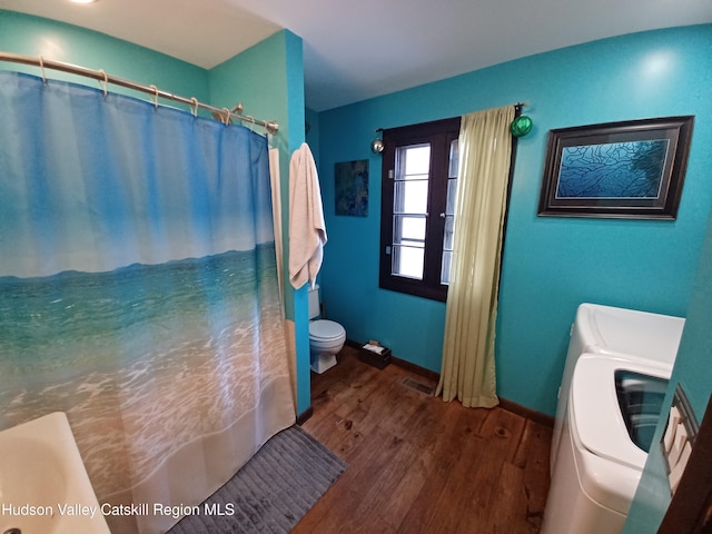 bathroom with hardwood / wood-style floors, toilet, and separate washer and dryer