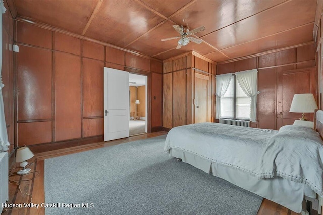 996 Dominican Ln, Saugerties, NY 12477 - bedroom with radiator, ornamental molding, wooden walls, wood finished floors, and ceiling fan