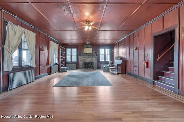 996 Dominican Ln, Saugerties, NY 12477 - unfurnished living room featuring radiator heating unit, ceiling fan, light wood finished floors, and a fireplace