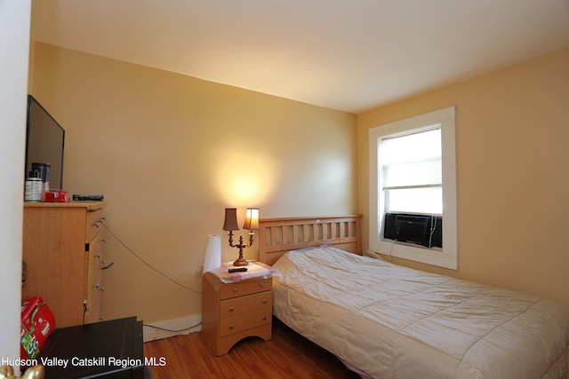 bedroom featuring wood-type flooring and cooling unit