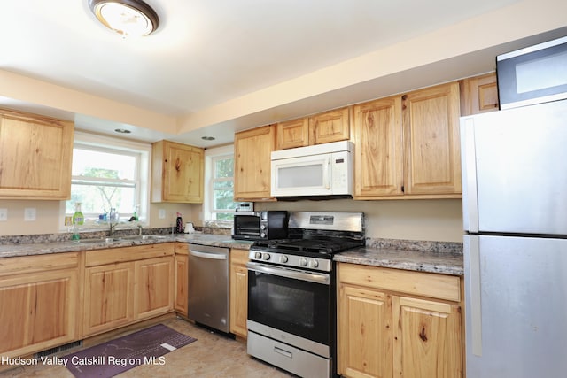 kitchen with light brown cabinetry, sink, and stainless steel appliances