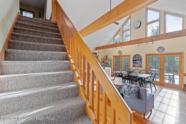 stairs featuring french doors, hardwood / wood-style flooring, high vaulted ceiling, and beamed ceiling