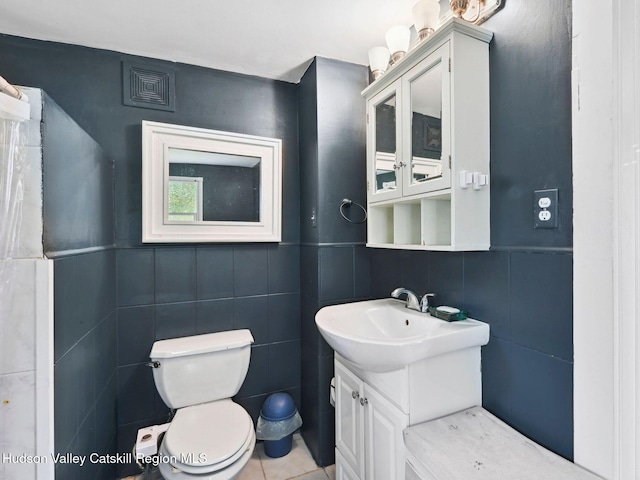 bathroom with tile patterned flooring, vanity, tile walls, and toilet