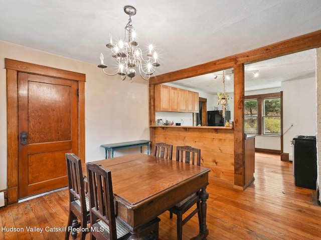 dining room featuring hardwood / wood-style flooring and an inviting chandelier