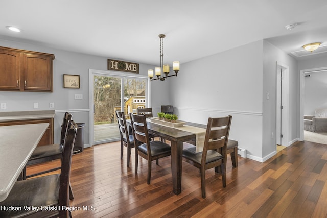 dining area featuring dark wood-style flooring, baseboards, recessed lighting, and a chandelier