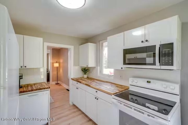 kitchen with white appliances, butcher block countertops, white cabinets, light wood finished floors, and baseboards