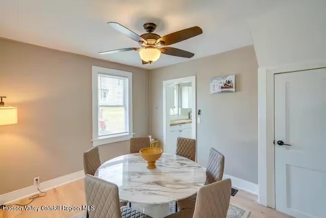 dining space featuring a ceiling fan and baseboards