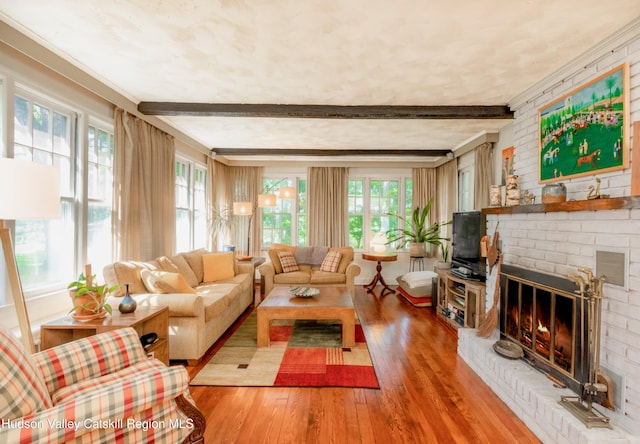 living room with hardwood / wood-style flooring, plenty of natural light, beam ceiling, and a fireplace