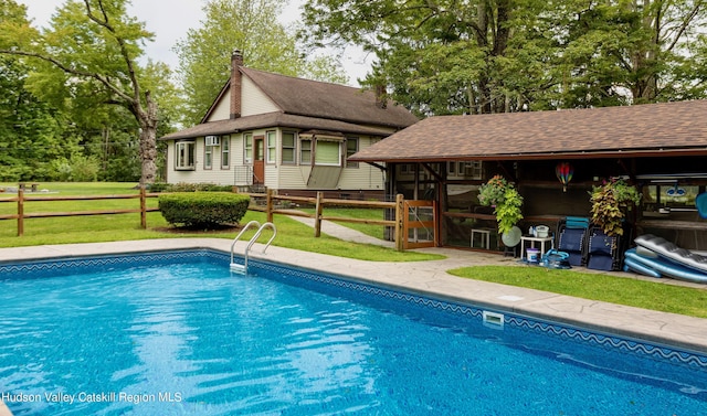 view of pool featuring a lawn