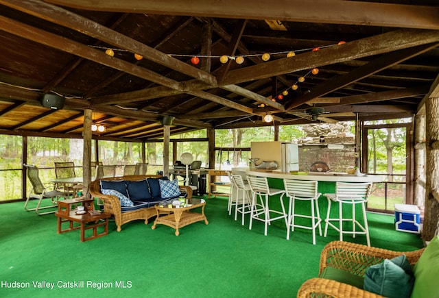 sunroom / solarium with vaulted ceiling with beams