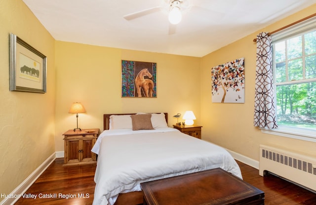 bedroom with ceiling fan, radiator heating unit, and dark wood-type flooring