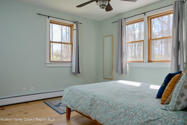 bedroom with a baseboard radiator and wood finished floors