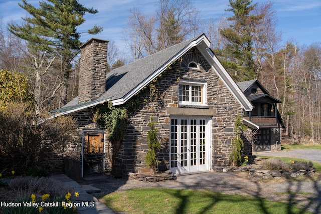 18 Striebel Rd, Woodstock, NY 12498 - view of side of home featuring roof with shingles, a chimney, french doors, and stone siding
