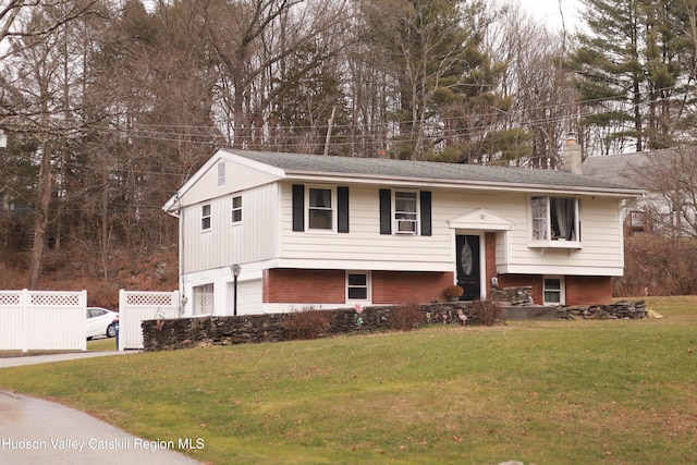 split foyer home featuring a garage and a front yard