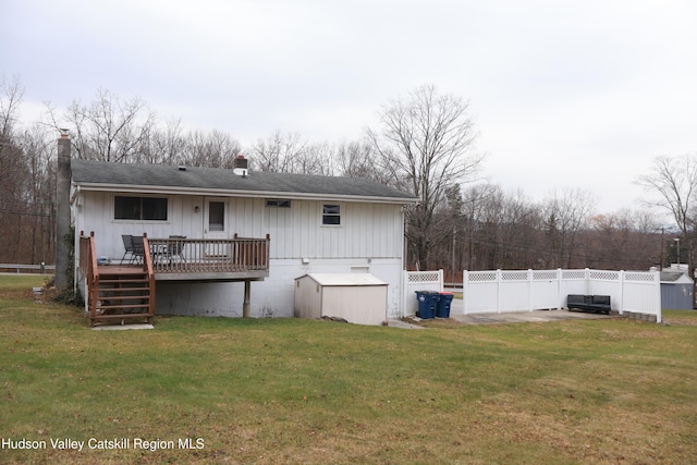 back of property featuring a lawn and a wooden deck