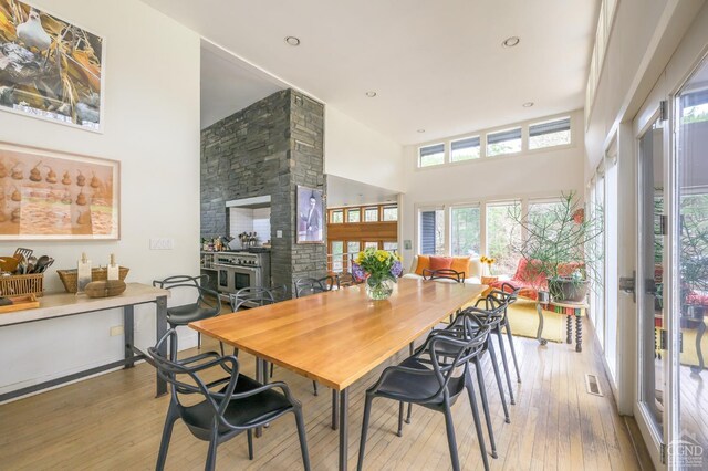5015 Crow Hill Rd, Austerlitz, NY 12165 - dining room featuring hardwood / wood-style flooring, a high ceiling, a fireplace, and recessed lighting