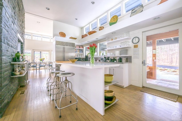 5015 Crow Hill Rd, Austerlitz, NY 12165 - kitchen featuring open shelves, a high ceiling, light wood-style flooring, built in fridge, and light countertops