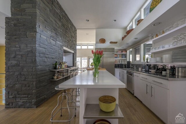 5015 Crow Hill Rd, Austerlitz, NY 12165 - kitchen featuring open shelves, stainless steel appliances, wood finished floors, white cabinetry, and a kitchen island