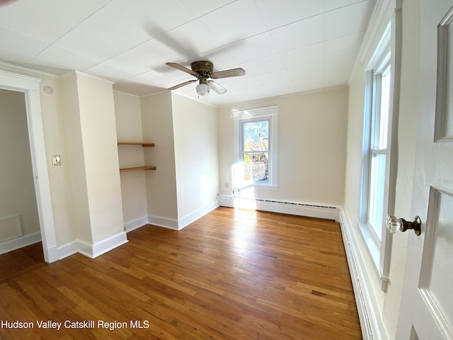 unfurnished room with wood-type flooring, a baseboard radiator, ceiling fan, and crown molding