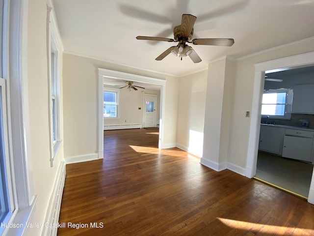 empty room featuring baseboard heating, dark wood-type flooring, a healthy amount of sunlight, and ornamental molding