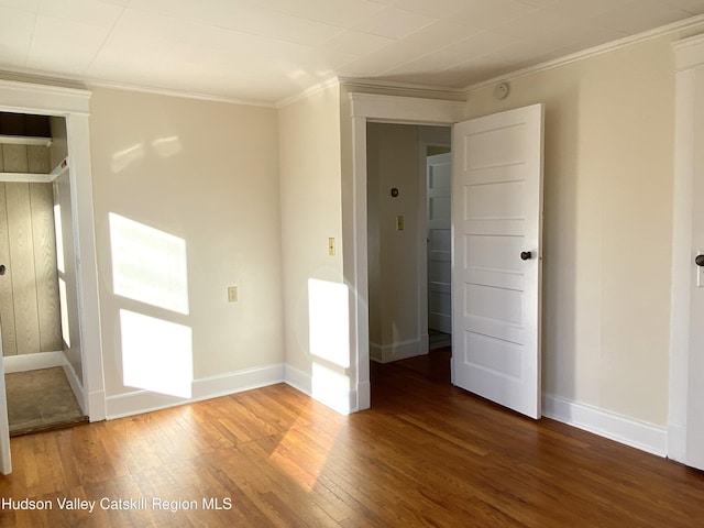 empty room featuring crown molding and dark hardwood / wood-style floors