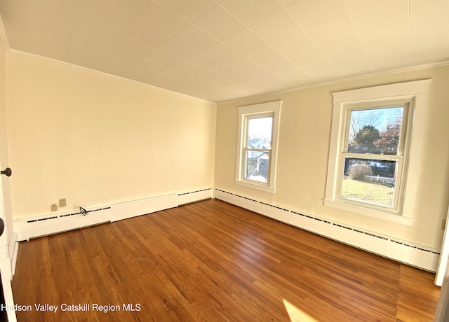 spare room with hardwood / wood-style flooring, crown molding, and a baseboard radiator