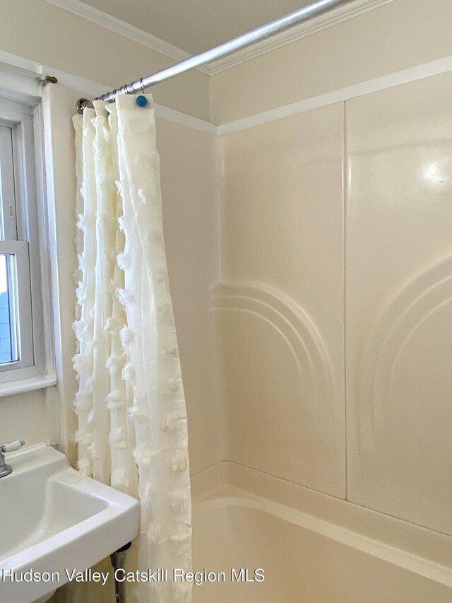 bathroom featuring crown molding, sink, and shower / bath combination with curtain